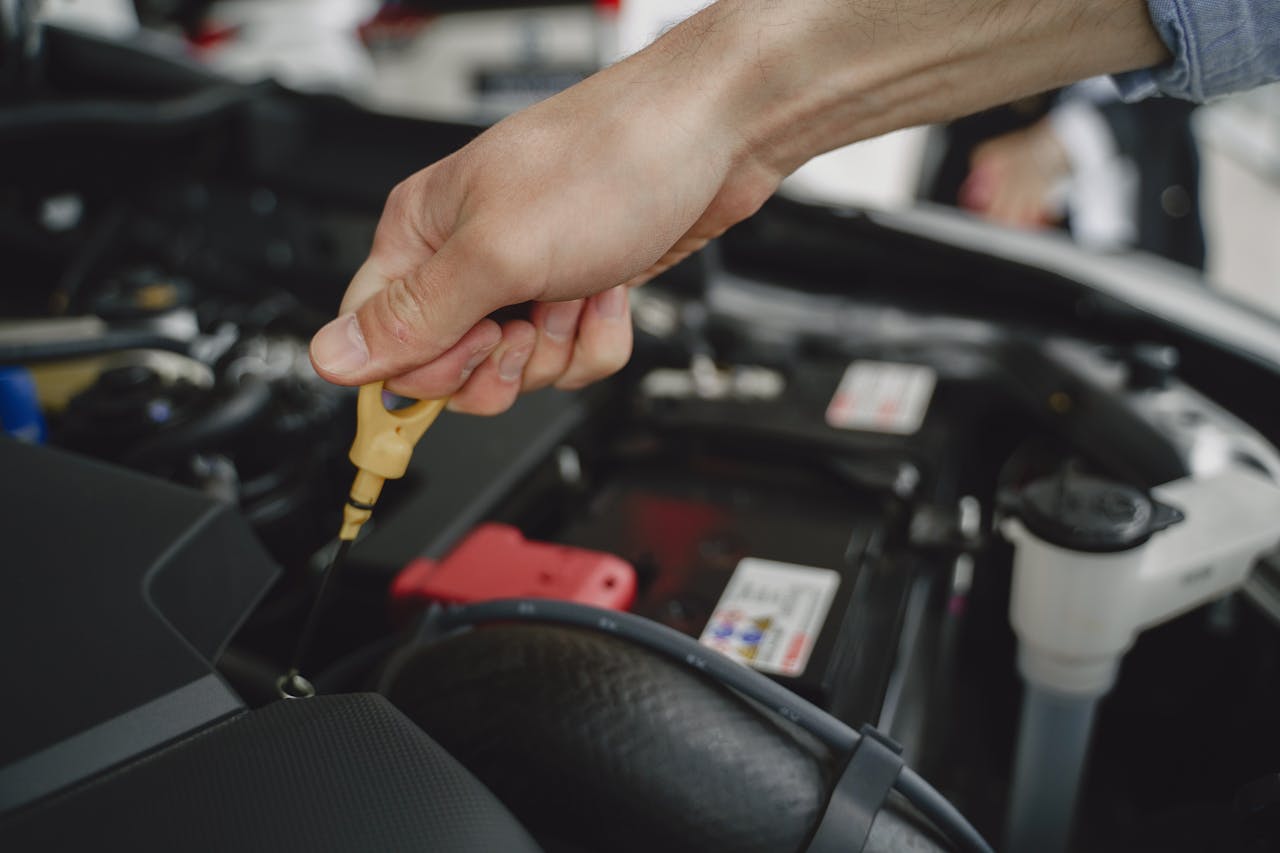 Crafting Captivating Headlines: Your awesome post title goes here Hand checking oil dipstick in a car engine bay for maintenance and diagnostics.